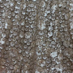 Close-up of silver-toned sequins with pearl-like floral embroidery on net