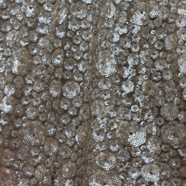 Close-up of silver-toned sequins with pearl-like floral embroidery on net