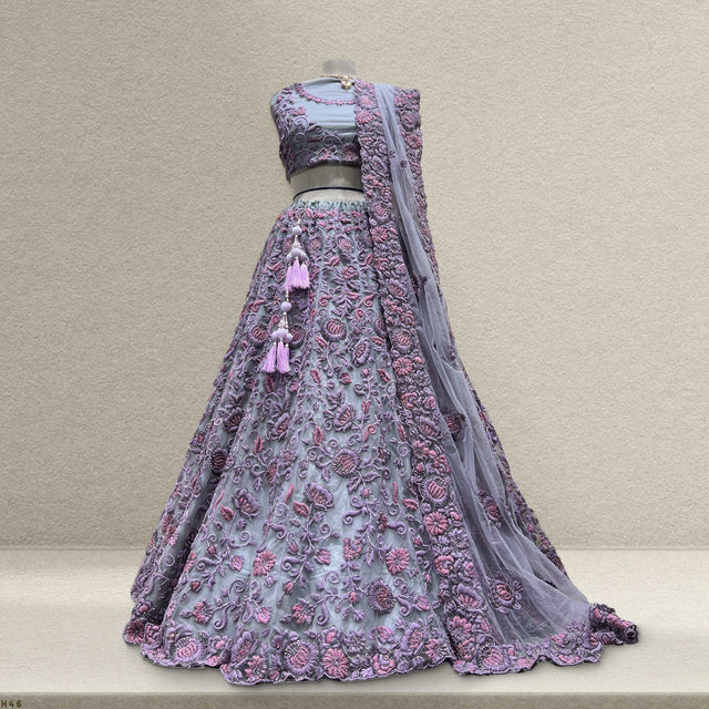Embroidered purple A-line lehenga with tassel accents and sheer dupatta draped at back