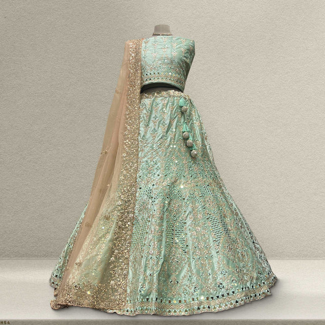 Velvet designer lehenga in aqua teal with mirror work and gold trim, flared skirt
