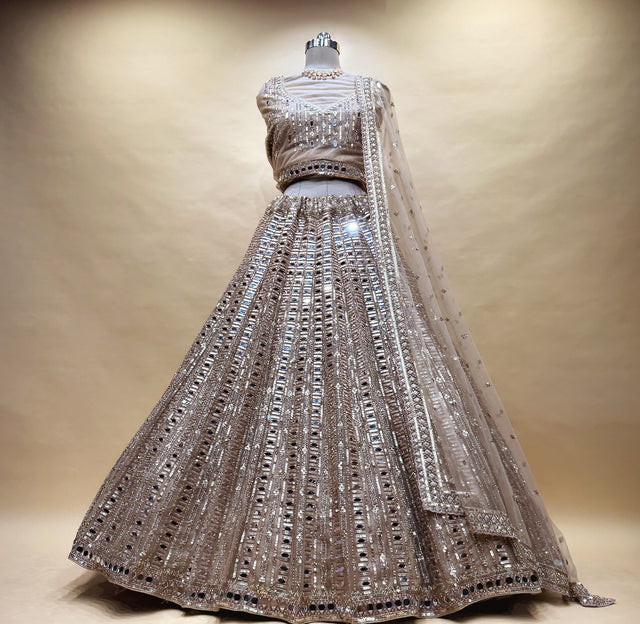 Ivory gold net mirror handwork lehenga on a mannequin with mirror columns, mirror blouse and net dupatta