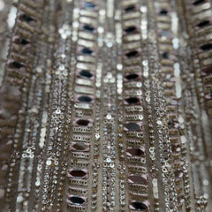 Close-up of mirror, sequins, and bead trim on a net lehenga skirt