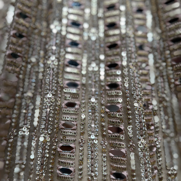 Close-up of mirror, sequins, and bead trim on a net lehenga skirt