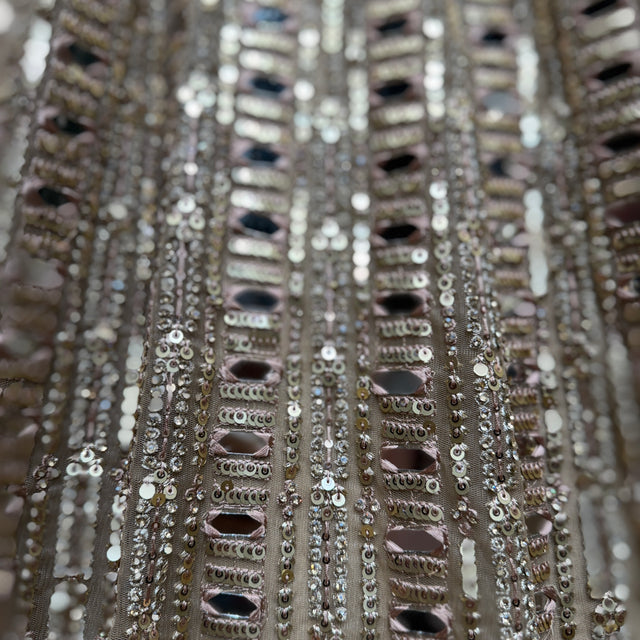 Close-up of mirror, sequins, and bead trim on a net lehenga skirt