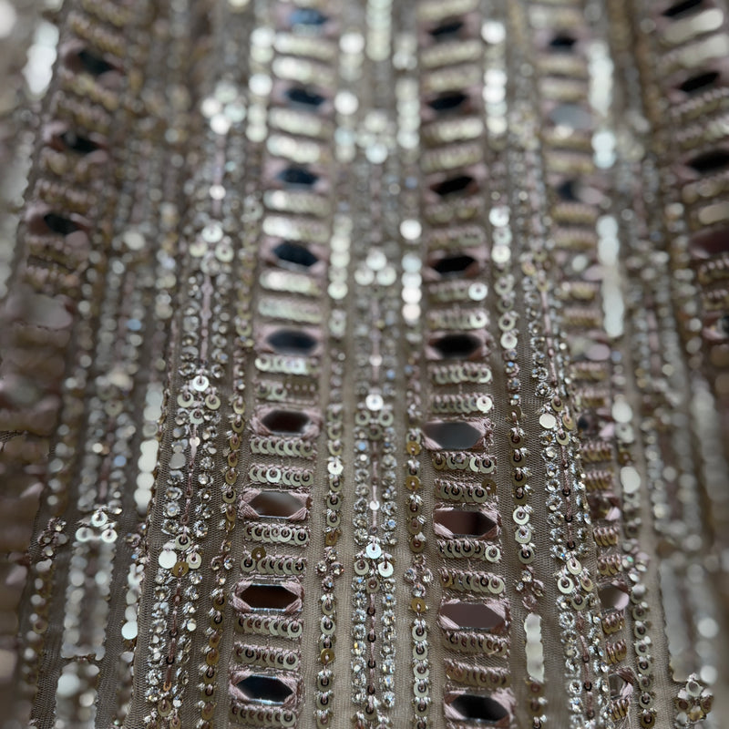 Close-up of mirror, sequins, and bead trim on a net lehenga skirt