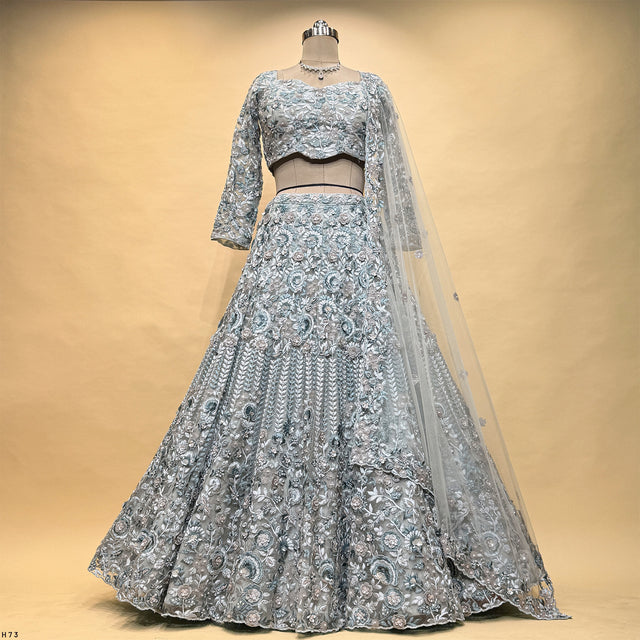 Mannequin wearing silver-gray embroidered lehenga skirt and cropped blouse with net dupatta