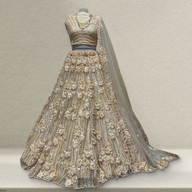 Ivory gold lehenga dress form with embellished bodice, flared skirt, and net dupatta