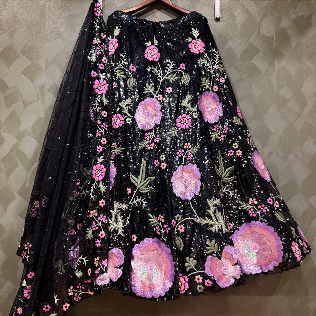 Black lehenga skirt detail with pink floral cutdana sequins and embroidered motif applique