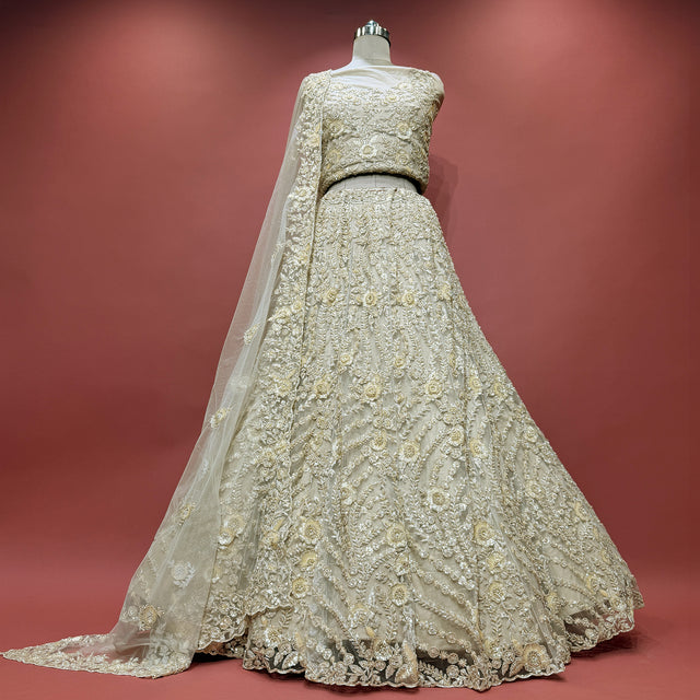 Ivory embroidered lehenga with sleeveless blouse and sheer dupatta overlay, flared skirt
