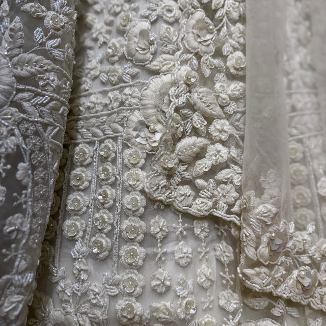 Close-up of white 3D floral cutwork embroidery on lehenga fabric