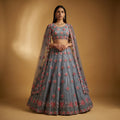 Dove grey lehenga with multicolor floral embroidery and pre-draped sheer cape dupatta