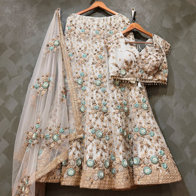Off-white lehenga on hangers with 3D floral resham, golden zari hem and net dupatta