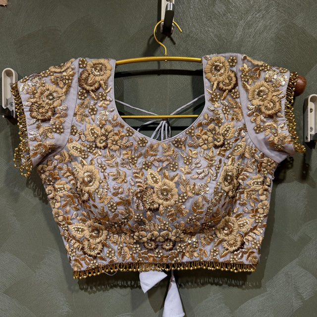 Lavender and gold beaded lehenga blouse top with floral motifs on hanger