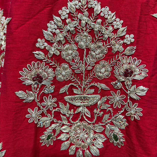 Close-up of royal red fabric with silver-toned zardosi floral embroidery