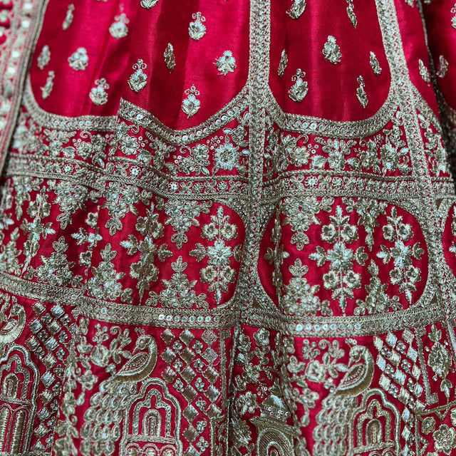 Royal red lehenga fabric with silver-toned floral embroidery and ornate trim