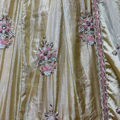 Close-up of butter yellow silk lehenga with pink, silver and bead floral embroidery
