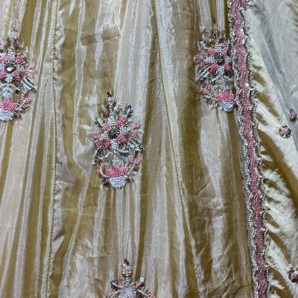 Close-up of butter yellow silk lehenga with pink, silver and bead floral embroidery