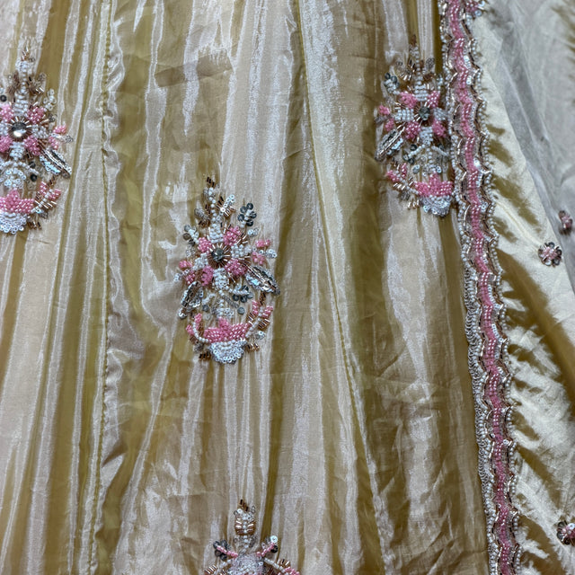 Close-up of butter yellow silk lehenga with pink, silver and bead floral embroidery
