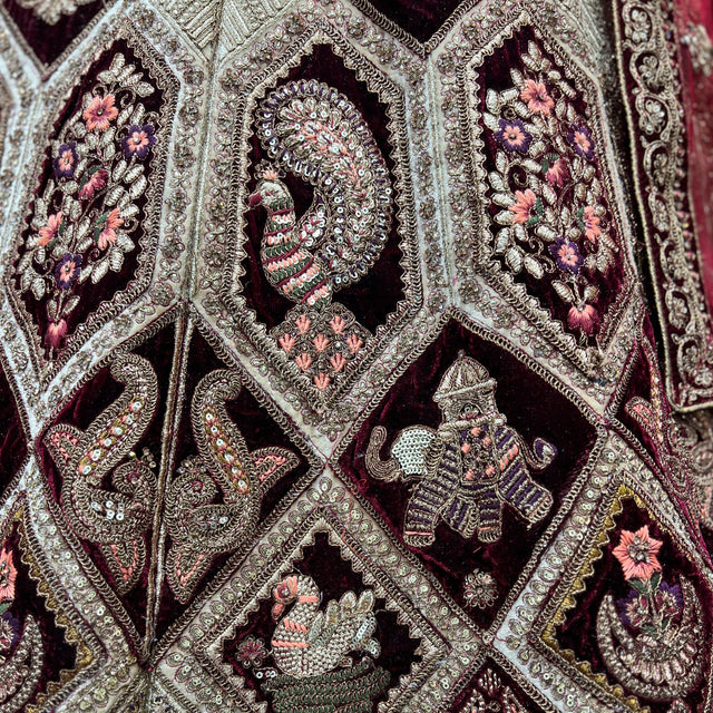 Velvet bridal lehenga fabric close-up with floral embroidery and metallic detailing