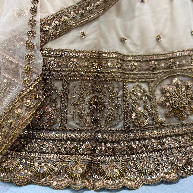 Embroidered beige lehenga hem with gold-toned beadwork and floral motifs