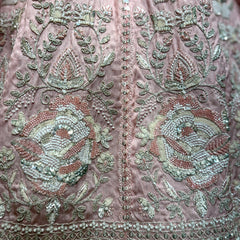 Embroidered pink fabric with beadwork floral motifs, green and silver details
