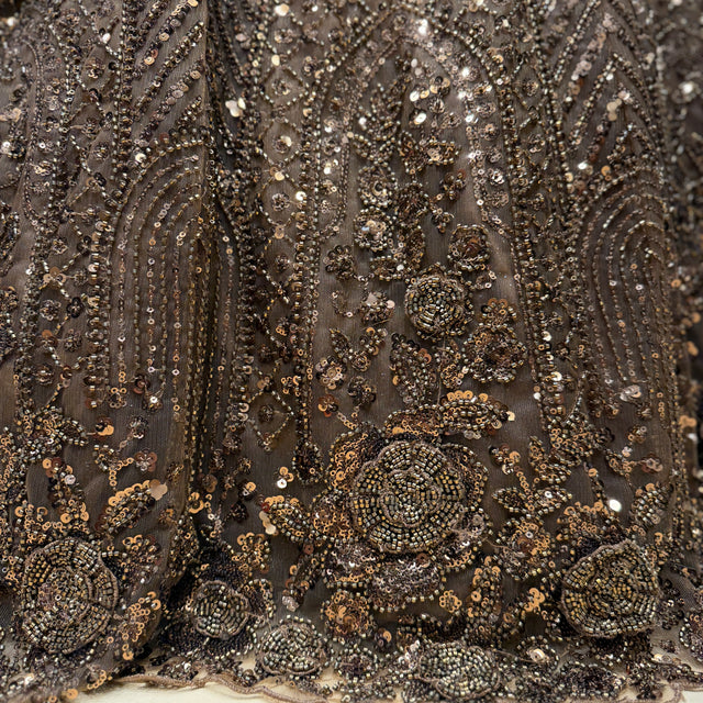 Beaded embroidered fabric close-up with metallic gold and dark silver embellishments