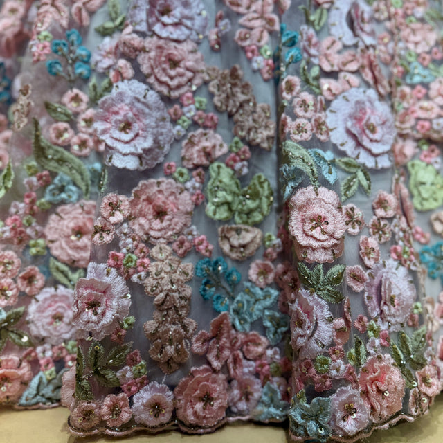 Close-up of 3D floral appliqué on pastel net fabric with embroidered details