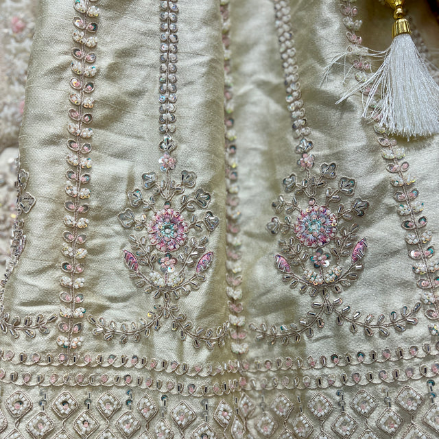 Ivory lehenga bodice with silver-gold embroidery and floral jeweled motifs; tassel trim