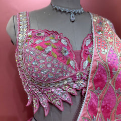 Close-up of the pink blouse with scalloped sweetheart neckline, leaf-shaped hem points and sequin and bead detailing in pink, silver and gold
