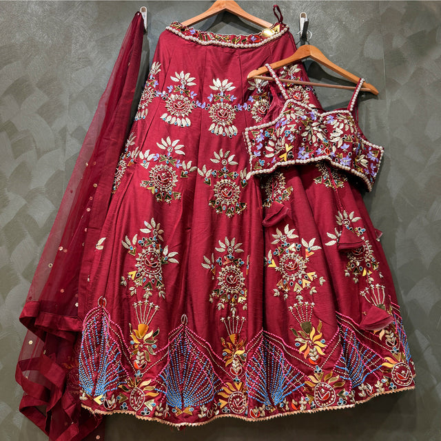 Maroon lehenga and matching blouse with mirror-and-bead embroidery; sheer dupatta