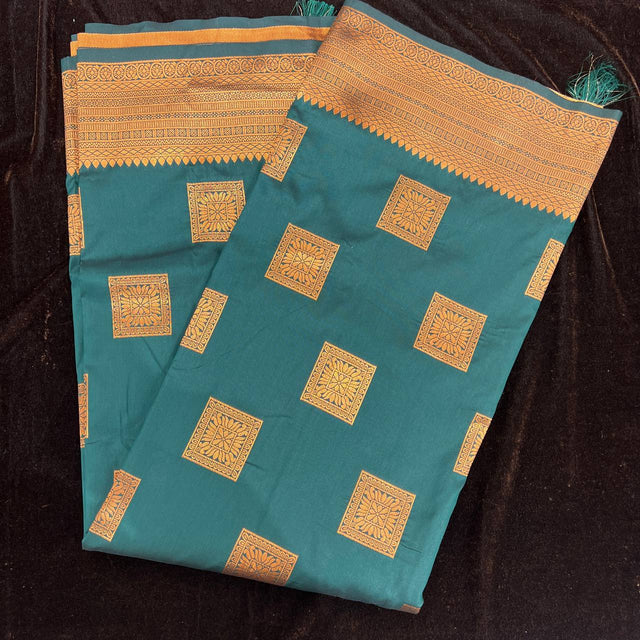 Teal silk saree folded flat with copper zari square motifs and patterned border