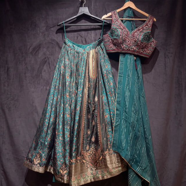 The teal viscose lehenga, wine handwork blouse and teal chinon dupatta on hangers