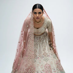 Close-up of the ivory embroidered blouse and skirt with a pink net dupatta embroidered with flowers and a scalloped edge, and a beaded latkan