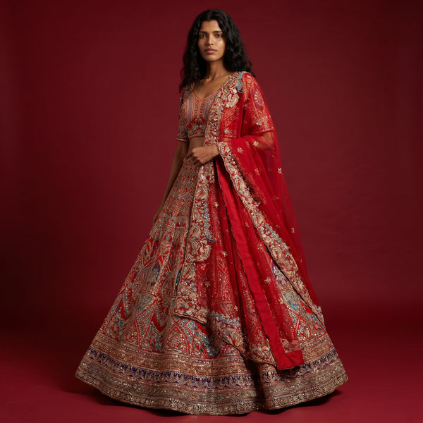Red bridal lehenga skirt with ornate gold embroidery and draped dupatta