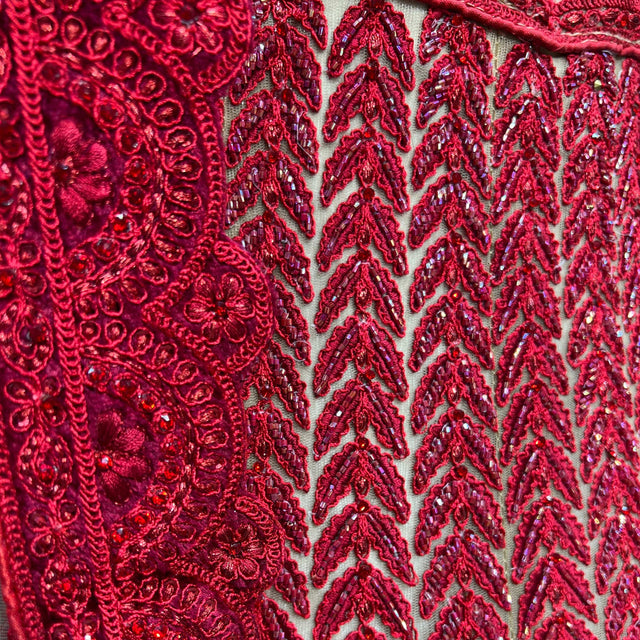 Red sequin and threadwork embroidery with zigzag and floral motifs, close-up