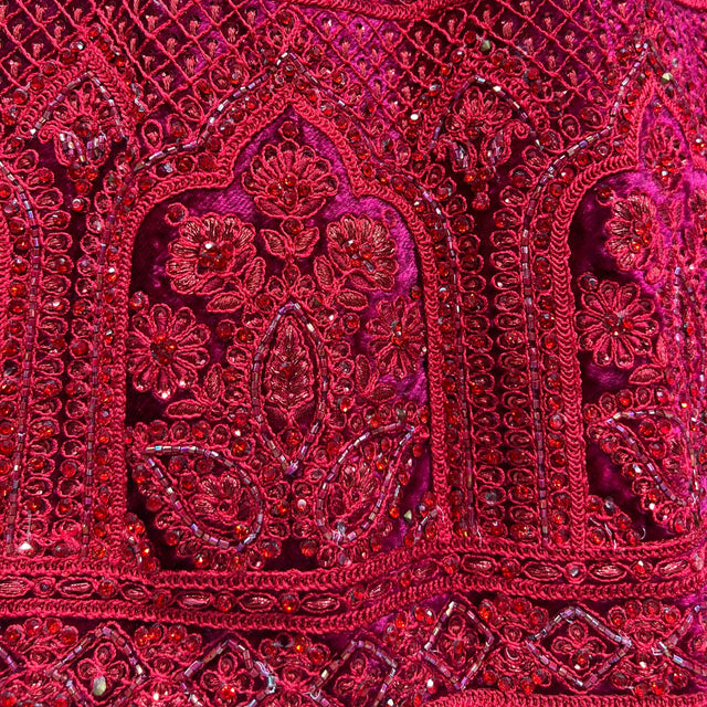 Red ornate lehenga panel with arched floral embroidery and dense bead embellishment
