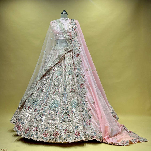 Embroidered bridal lehenga with soft pink dupatta, full flare skirt on mannequin