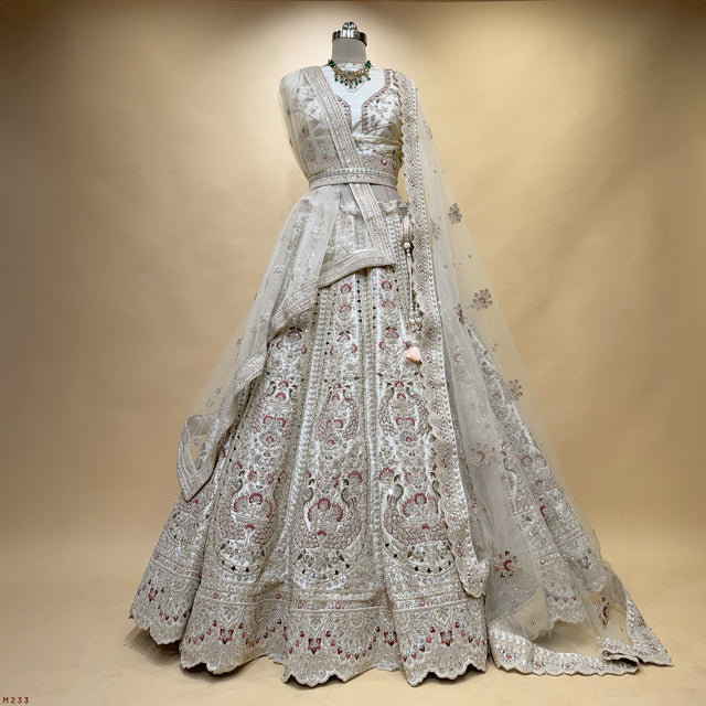 Ivory raw silk bridal lehenga with ornate mirror and zari peacock embroidery, full skirt