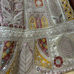 Detail of the lehenga patchwork panels in mustard, maroon and pink with mirrors, leaf motifs and tonal thread borders