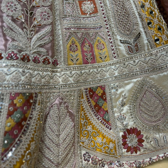 Detail of the lehenga patchwork panels in mustard, maroon and pink with mirrors, leaf motifs and tonal thread borders