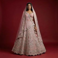 Soft pink lehenga with ornate embroidery, silver trim, and matching sheer dupatta veil