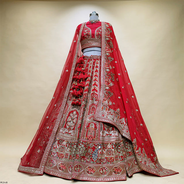 Red bridal lehenga skirt with dense embroidered motifs and silver-toned border, with dupatta.