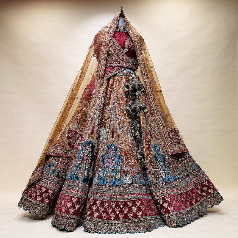 Embroidered bridal lehenga with layered flared skirt, maroon base, teal and gold motifs