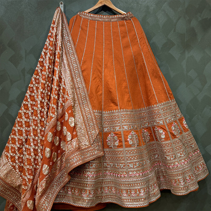 Orange raw silk bridal lehenga skirt with silver-toned embroidered hem and dupatta border