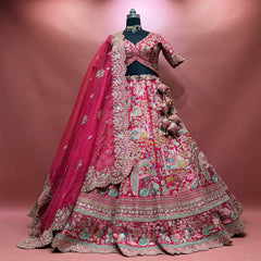 Pink raw silk lehenga set on a mannequin with heavy organza cutwork dupatta, tassels and village-scene embroidery