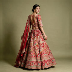 Back view of a red raw silk bridal lehenga with embroidered blouse, full skirt and organza dupatta