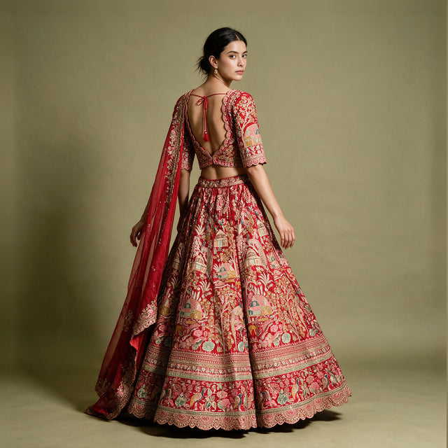 Back view of a red raw silk bridal lehenga with embroidered blouse, full skirt and organza dupatta