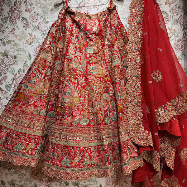 Red embroidered lehenga skirt with ornate borders and layered hem