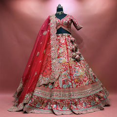 Red raw silk lehenga set on a mannequin with heavy organza cutwork dupatta, tassels and village-scene embroidery