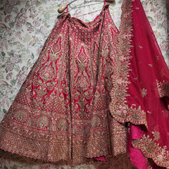 Pink and gold lehenga skirt laid out showing gold motifs, zari and stone work bands and scalloped cutwork dupatta